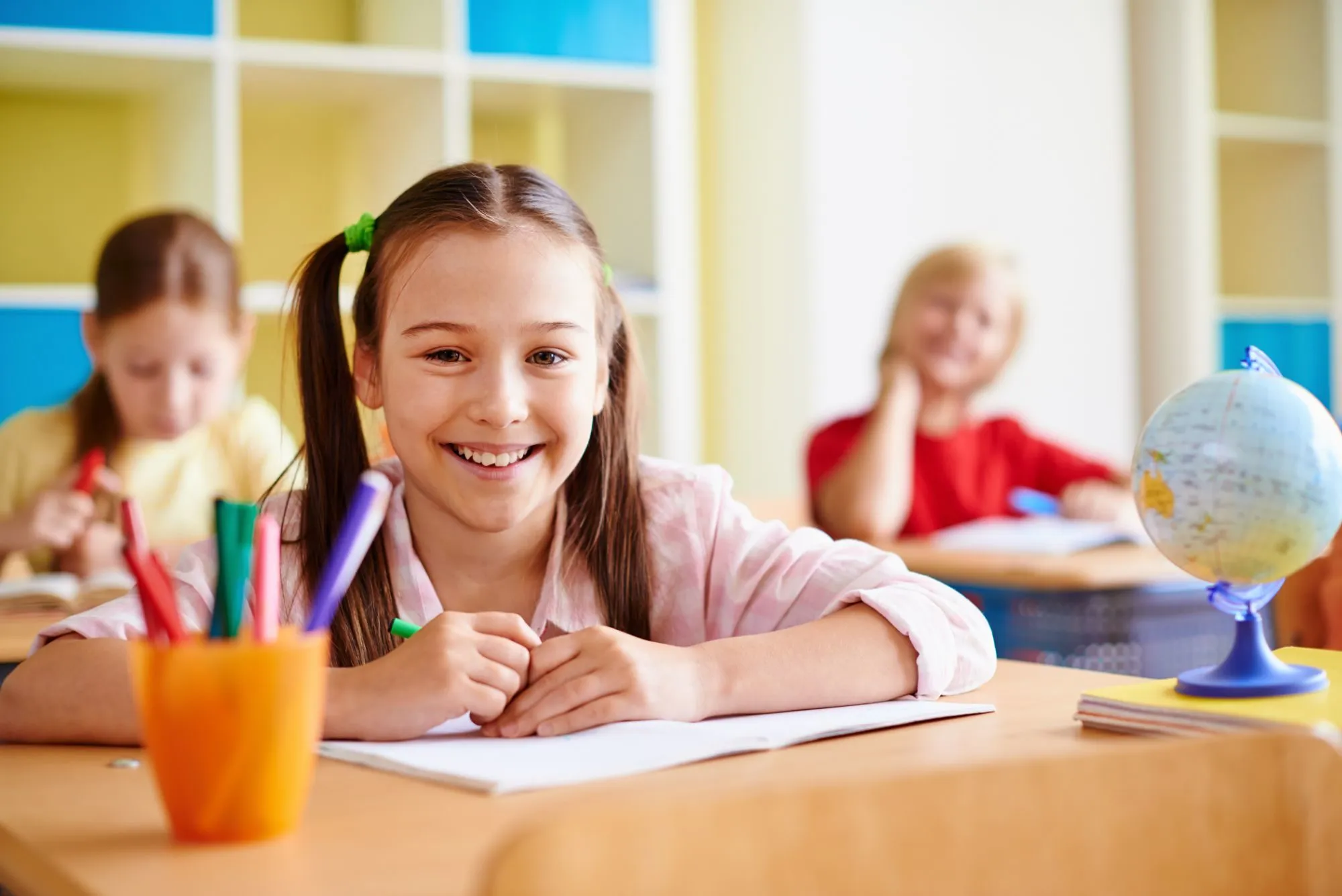 Portrait of lovely girl looking at camera at lesson of drawing